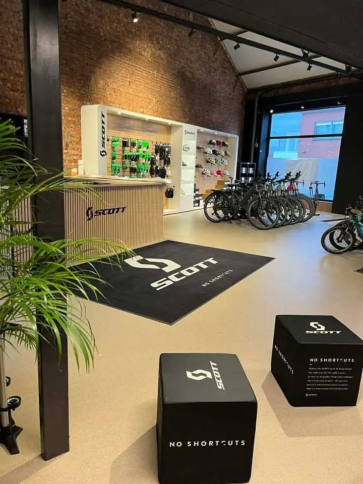 Overzicht van de nieuwe VRG Bikes winkel met houten balie, accessoires en fietsen